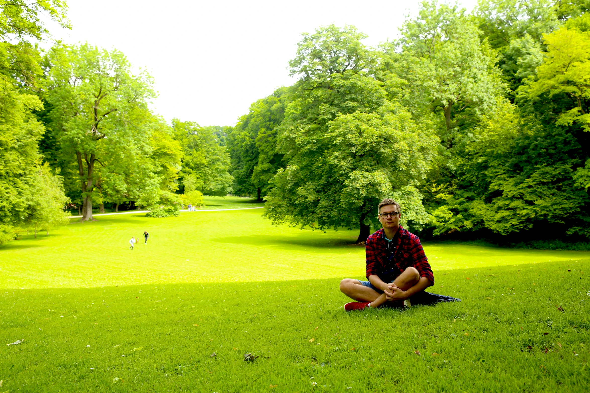 a man sits in the middle of the grass