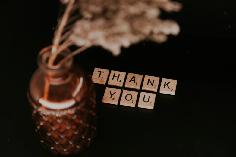 a small glass vase with some letters written on it