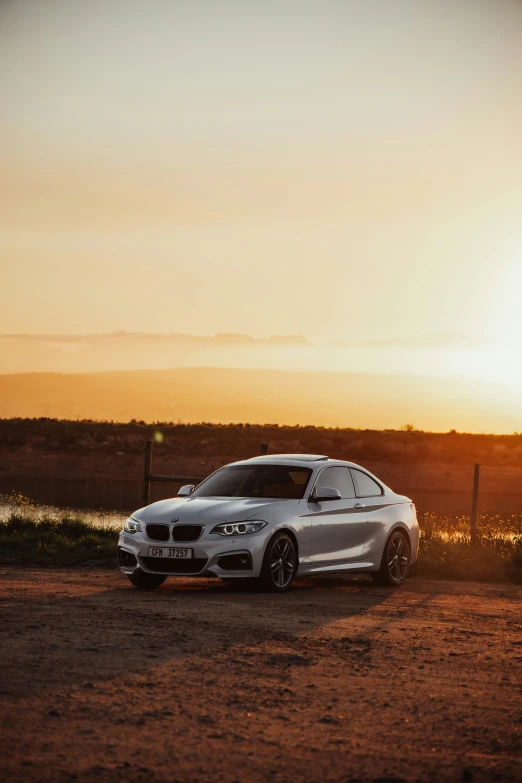 the grey car is parked in a field