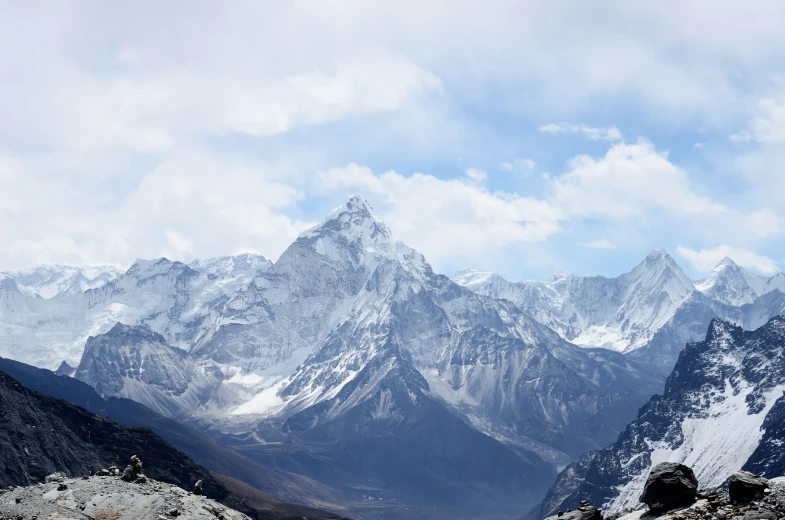 a very tall mountain with white snow covered mountains in the background