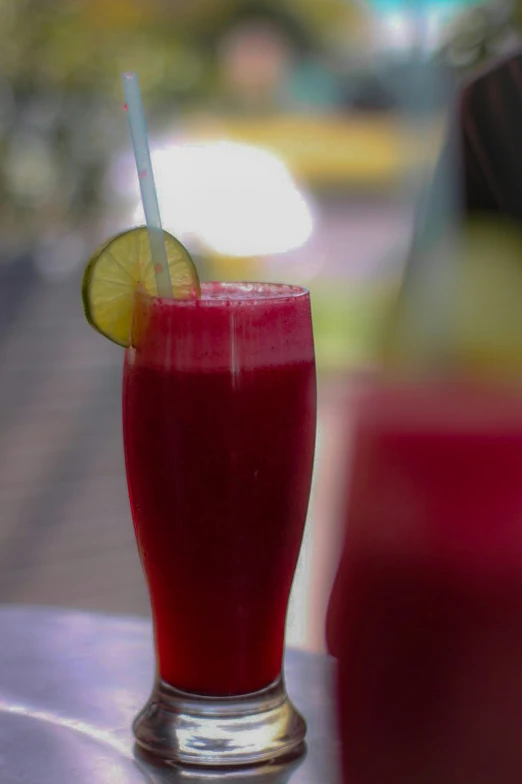 a close up of a drink with a straw and a lime