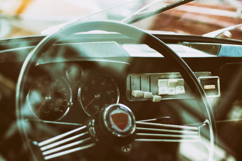 the interior of an old style car, taken from the steering wheel