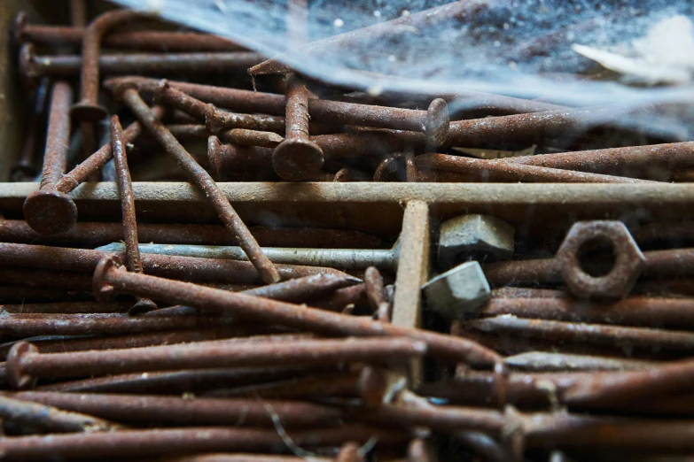 a large group of nails and wooden dows in a box