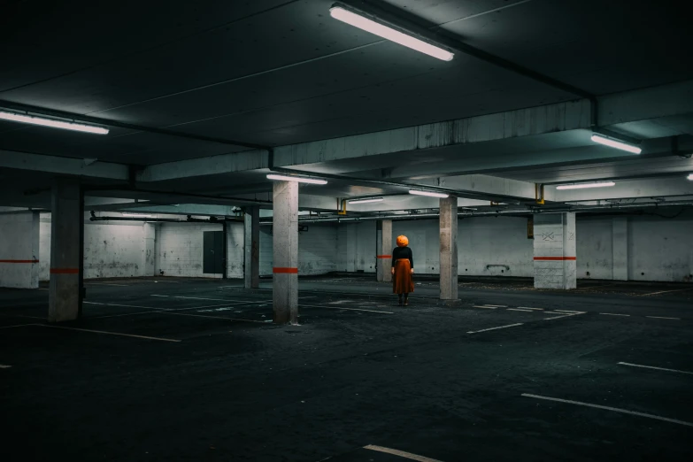 a person standing in a parking garage in an area that appears empty