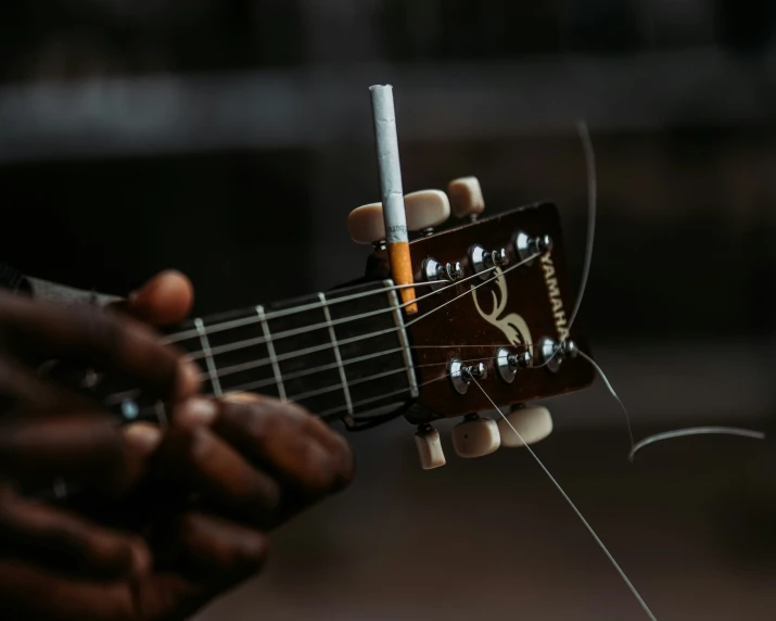 a person playing on top of a guitar with their fingers