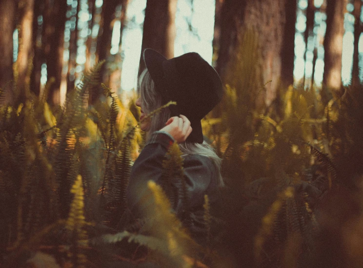 woman with flowers in hand in a forest