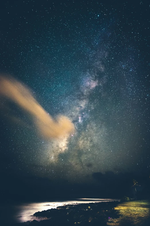 a night scene with a body of water and stars