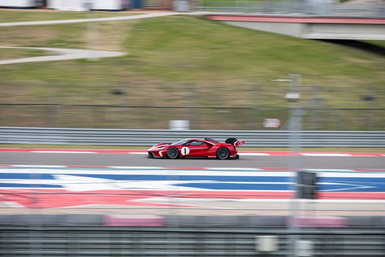 a red sports car driving down a race track