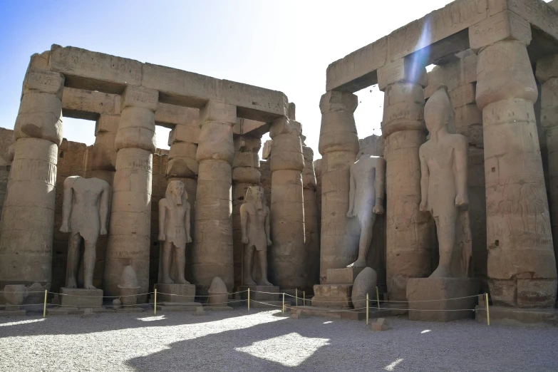 the sun shines on ancient statues of ancient egypt