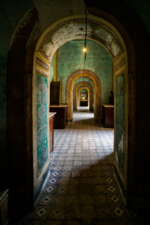 light pouring in between an arched doorway to a hall