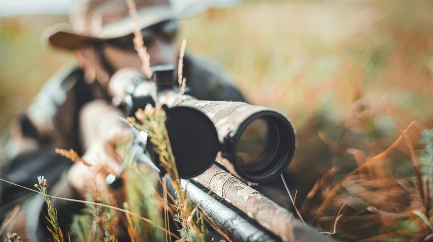 a rifle is laying on the ground next to a gun