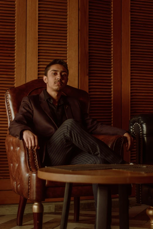 a man in a leather chair and black suit