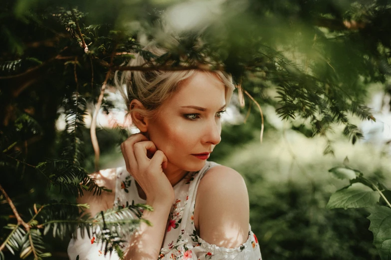 a woman is hiding behind a tree