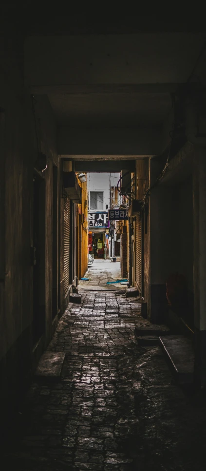 a long narrow walkway with yellow doored buildings on each side