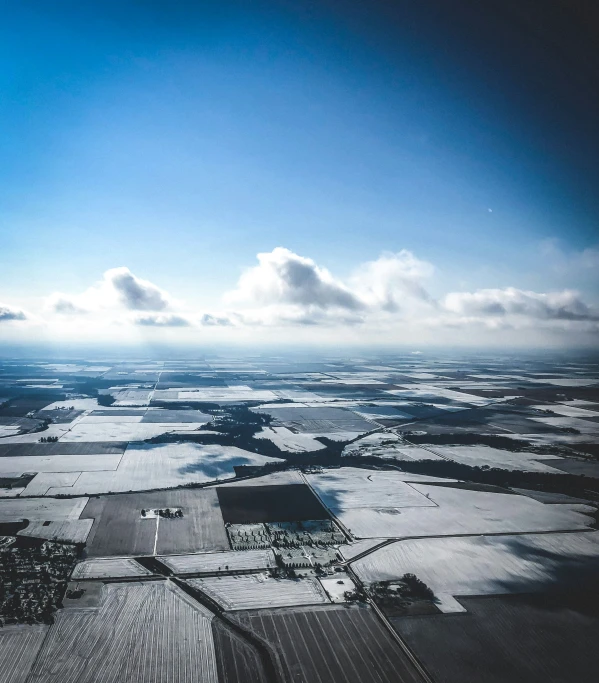 a field of frozen grass near an industrial district