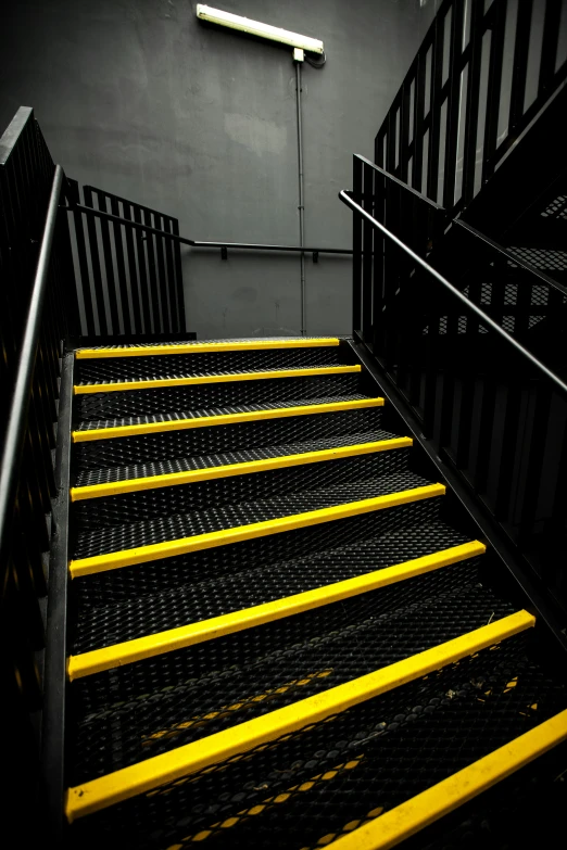 a black stair case with yellow steps on it