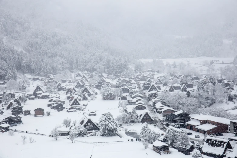 a town in the middle of a snowstorm with houses on the hill