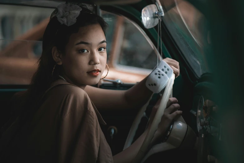a young woman sitting behind the steering wheel of a car