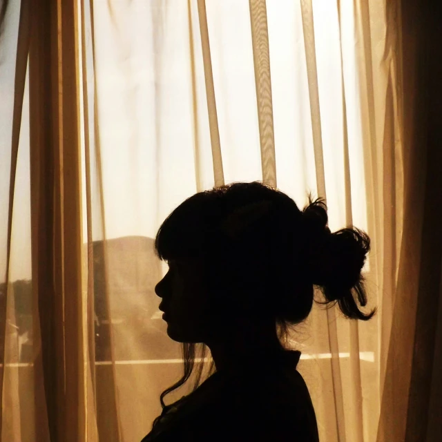 a woman looks out the window with a mountain backdrop