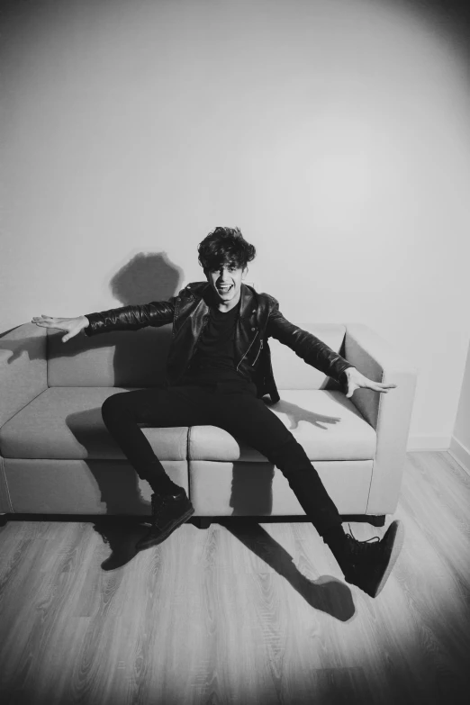 a young man sitting on top of a sofa