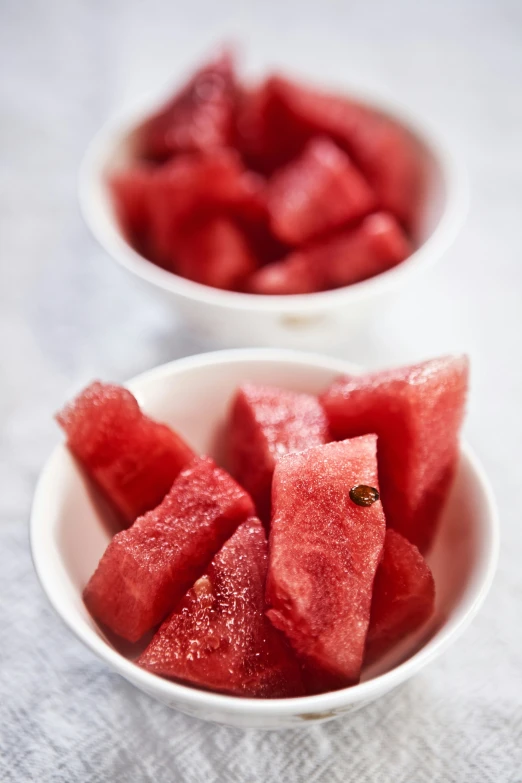 a bowl of slices of watermelon are on a table