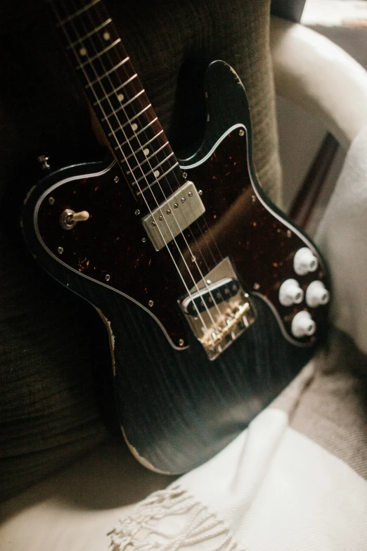 a guitar sits on a seat, with its case