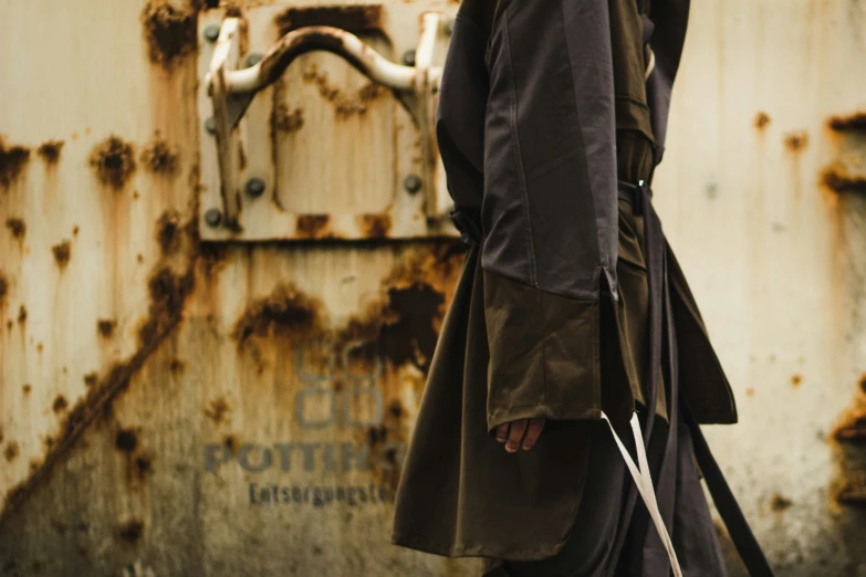 a woman with a cane standing next to a rusty building