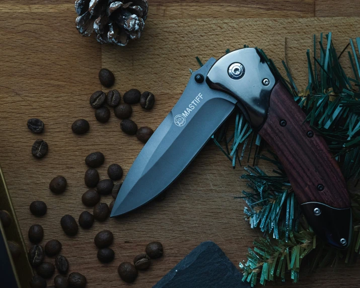 this knife is open on a table next to nuts and pine cones