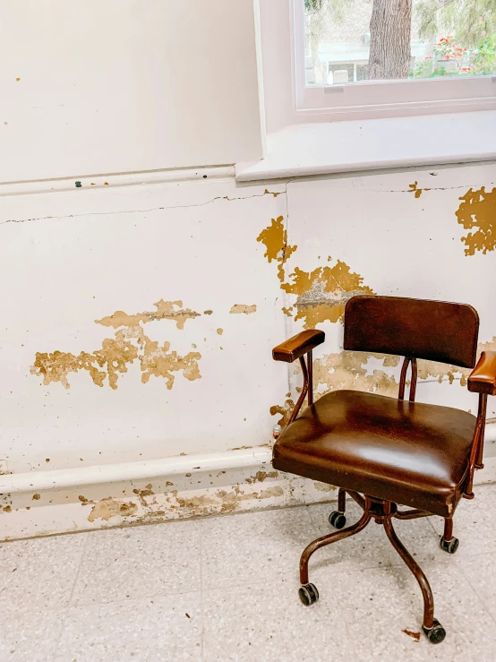 a chair that is sitting in a room with mold on the walls