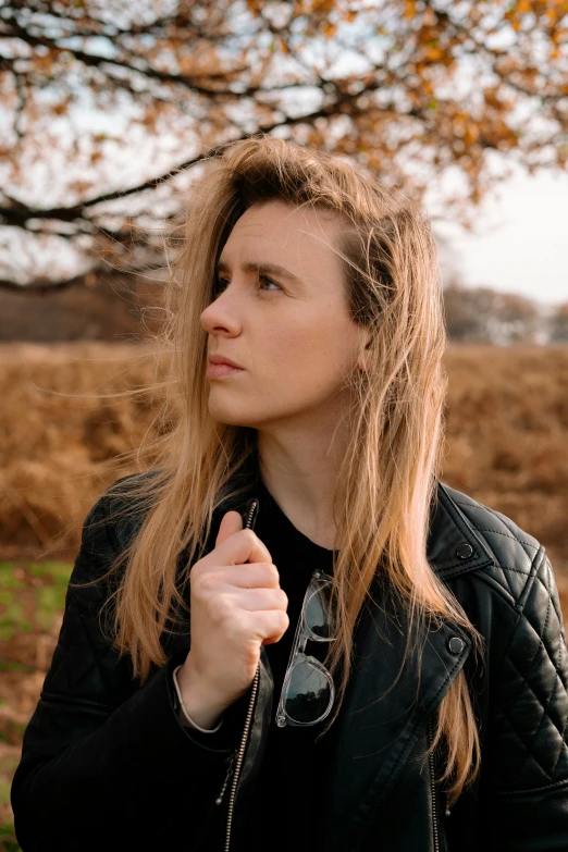 a woman standing in front of a tree