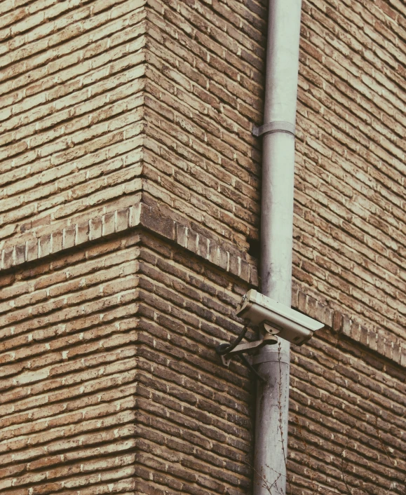 a very tall brick building with a metal pole