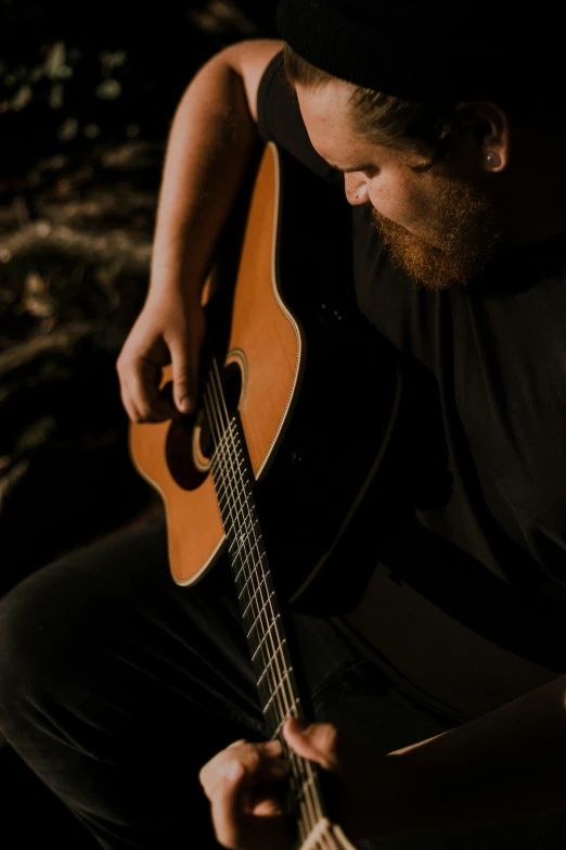 the man is holding an acoustic guitar in his hand