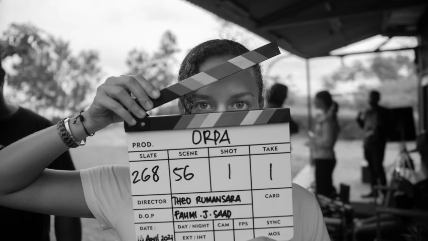 a man holding up a movie clapper to his face