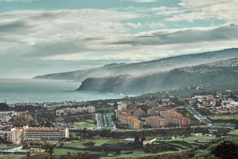 clouds loom over a small city next to a body of water