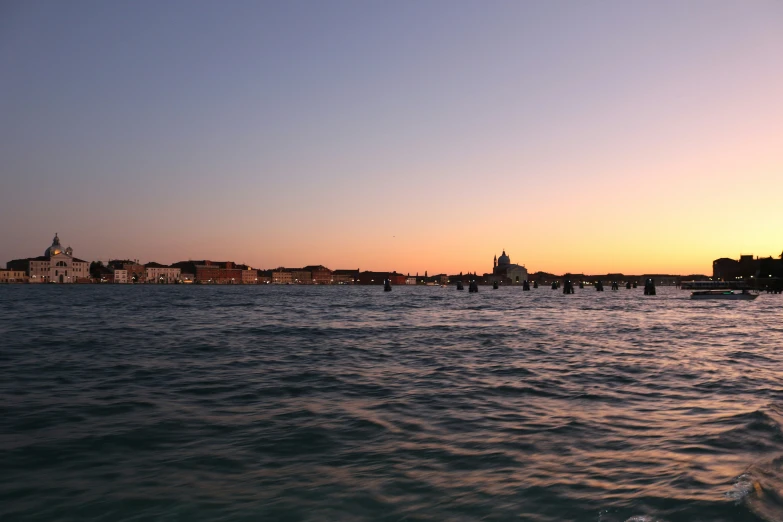 view of a town over water with ships at sea