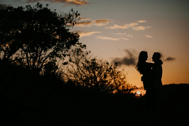 couple silhouettes at sunset, in a field