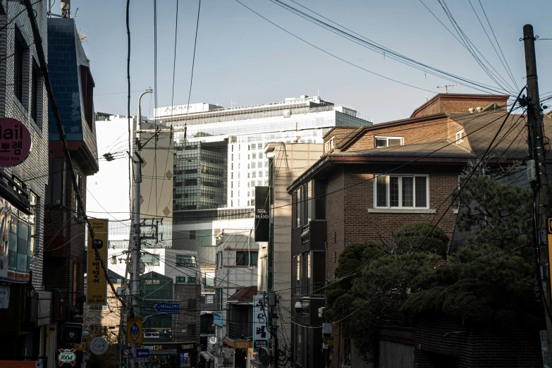 a street is surrounded by tall buildings and wires