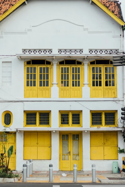 a white building with yellow windows has a blacktop on top