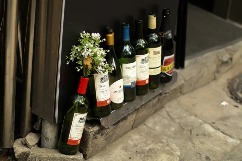 bottles and a vase sitting on the ground next to a window