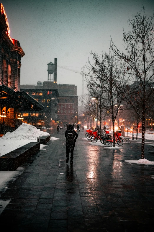 a woman is walking down the street in the winter