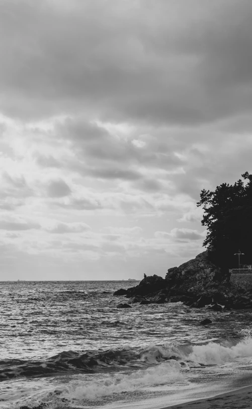 black and white pograph of lighthouse on cliff above the ocean