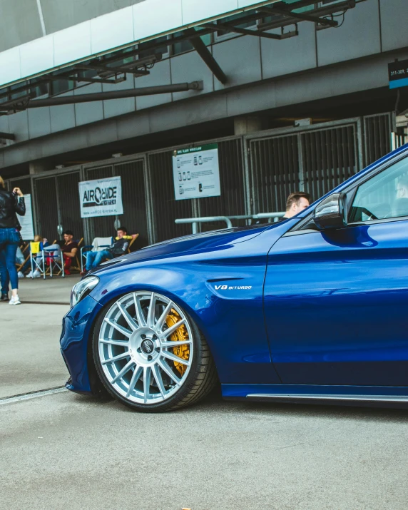 the bmw is parked on the street with people watching