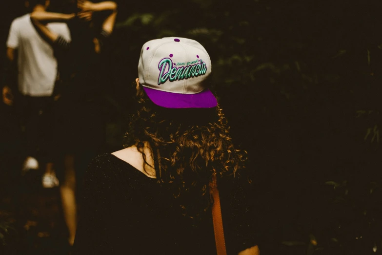 a woman wearing a black shirt and a purple hat