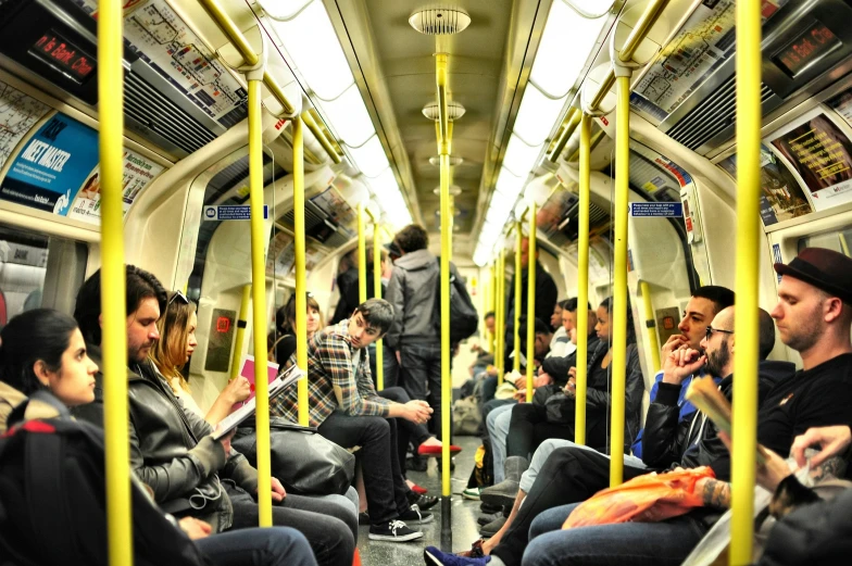 a crowded subway train car with passengers wearing hats and backpacks