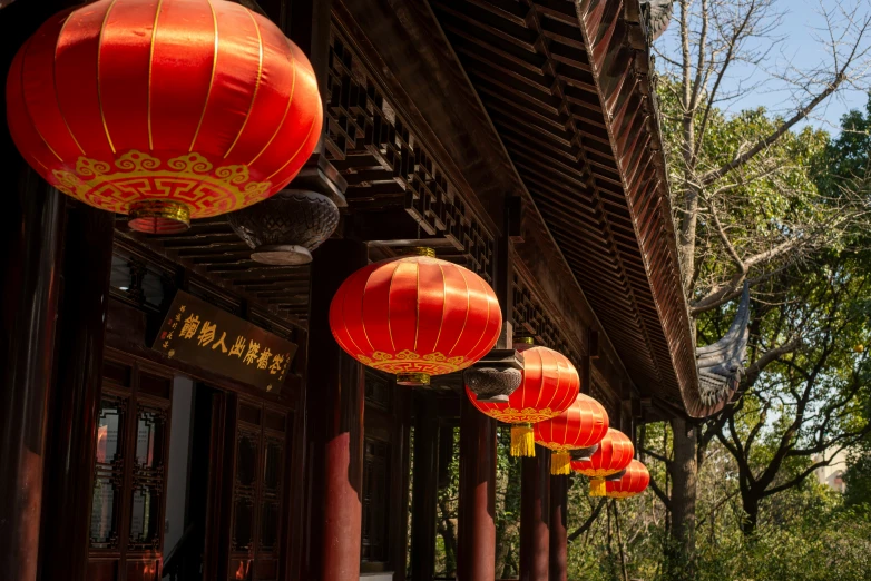 the red lanterns are hanging down on the building