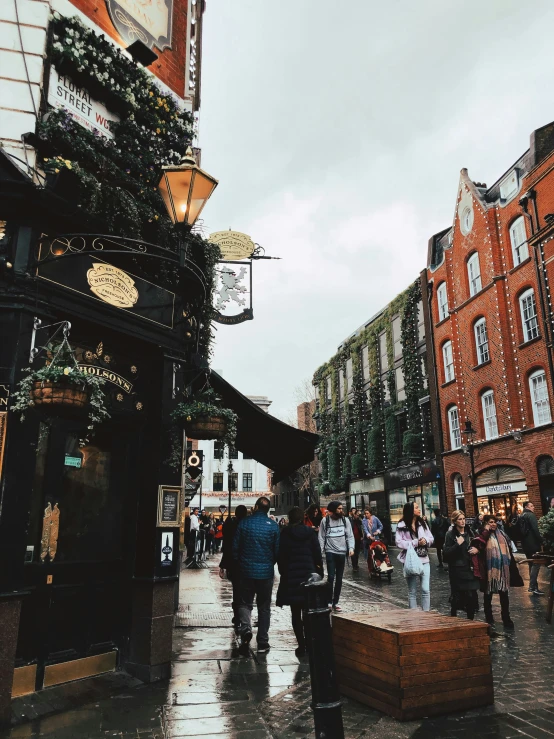 a group of people walking on a rainy sidewalk in a city