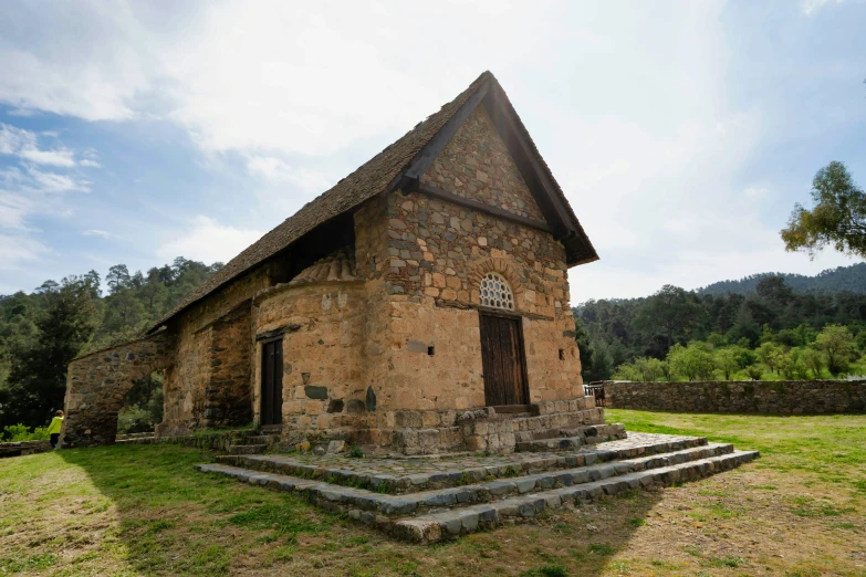 an old stone building sitting on a grassy hill