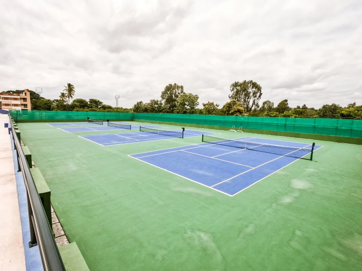 the tennis courts are empty with blue tennis net