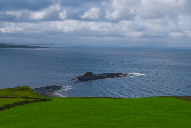 the ocean has waves on it near a small island