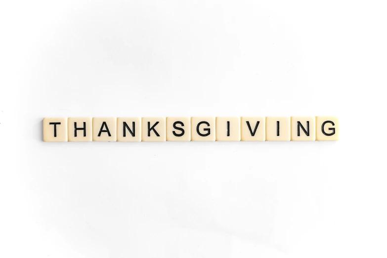 a scrabble letter spelling out the word thanksgiving